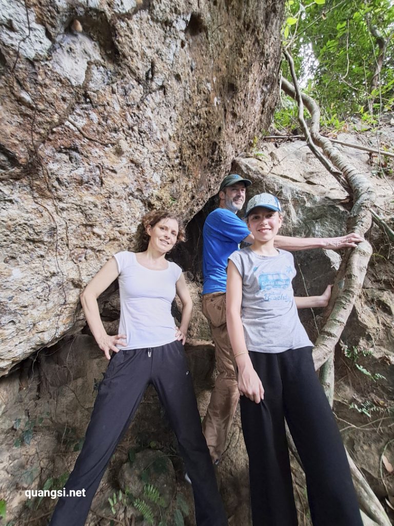 a group of people standing in front of a rock wall